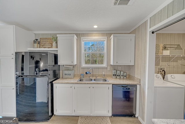 kitchen with black appliances, white cabinets, sink, and separate washer and dryer