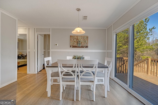 dining space featuring light hardwood / wood-style floors and ornamental molding