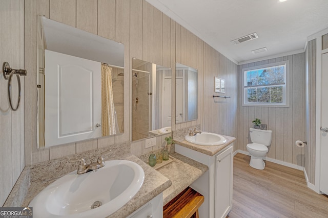 bathroom with toilet, vanity, hardwood / wood-style floors, a shower with curtain, and crown molding