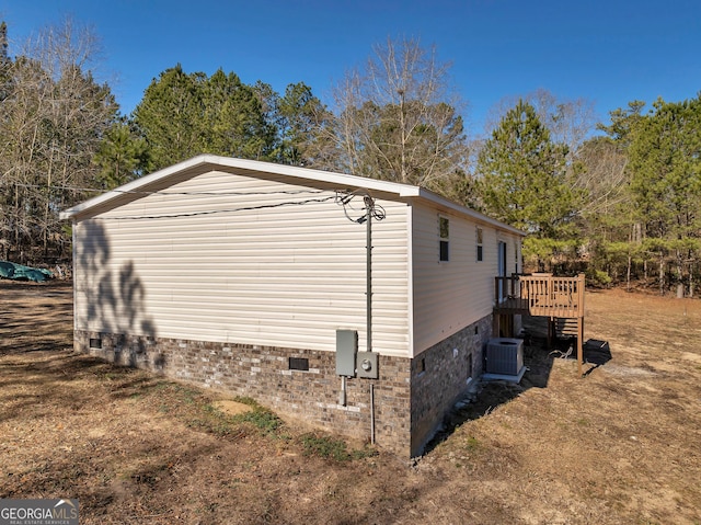 view of side of property featuring a deck and cooling unit