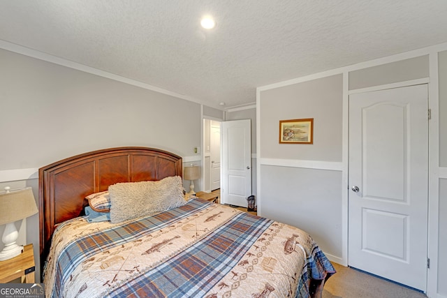 carpeted bedroom with crown molding and a textured ceiling