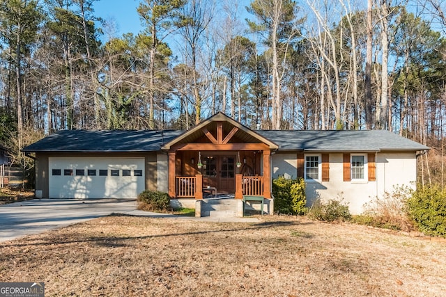 ranch-style house with a porch, a garage, and a front yard