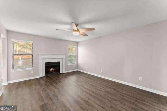 unfurnished living room with ceiling fan, a wealth of natural light, and dark hardwood / wood-style floors