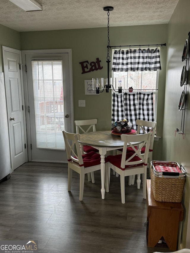 dining room with a textured ceiling, dark hardwood / wood-style flooring, and breakfast area