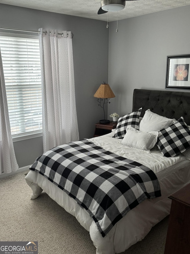 bedroom featuring a textured ceiling, ceiling fan, and carpet flooring