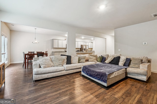 living room featuring dark hardwood / wood-style floors and an inviting chandelier