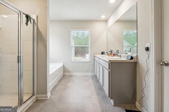 bathroom featuring vanity, plenty of natural light, and plus walk in shower