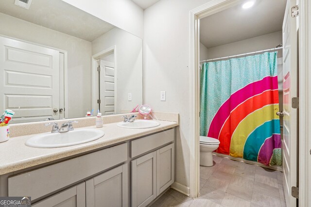 bathroom featuring toilet, vanity, and a shower with shower curtain