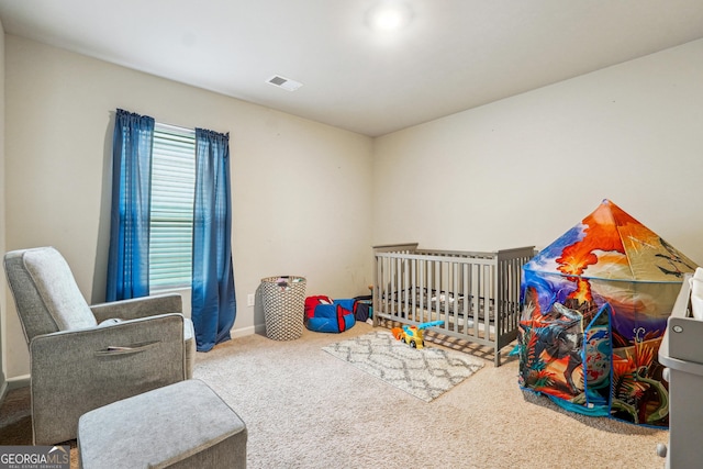 carpeted bedroom featuring a nursery area