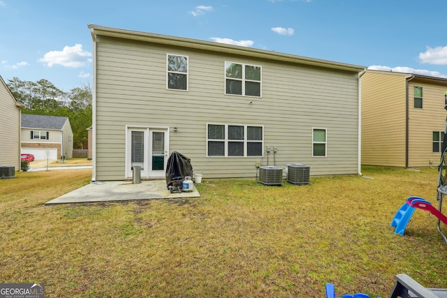 rear view of property featuring central AC unit, a yard, and a patio