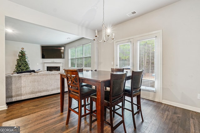 dining space featuring dark hardwood / wood-style floors and a notable chandelier