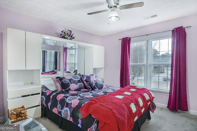 bedroom with a ceiling fan, light carpet, visible vents, and baseboards