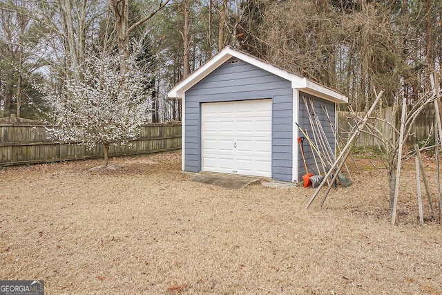 detached garage featuring fence