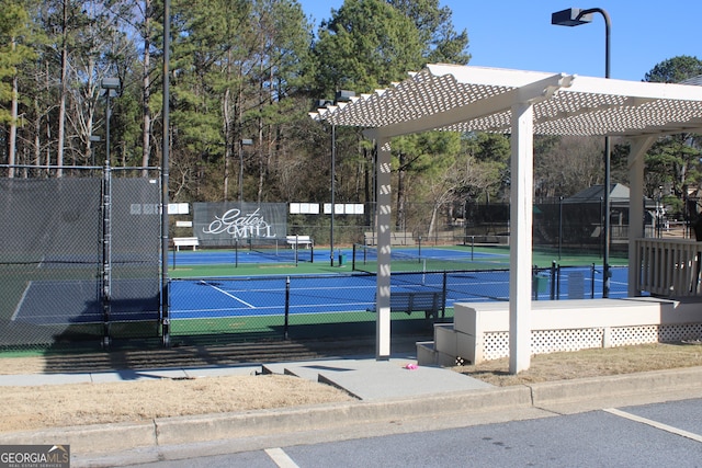 view of tennis court featuring a gate, fence, and a pergola