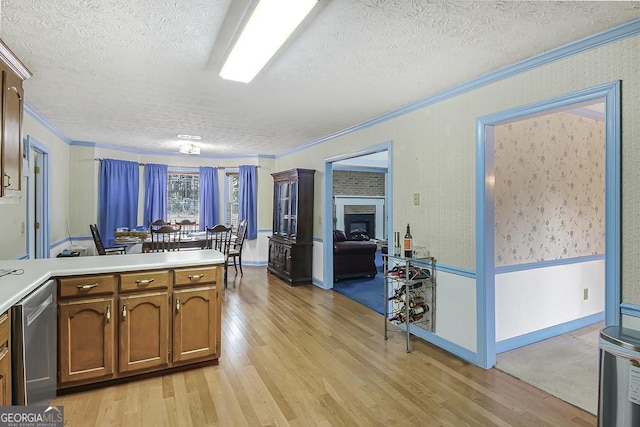 kitchen with light wood finished floors, crown molding, and dishwasher