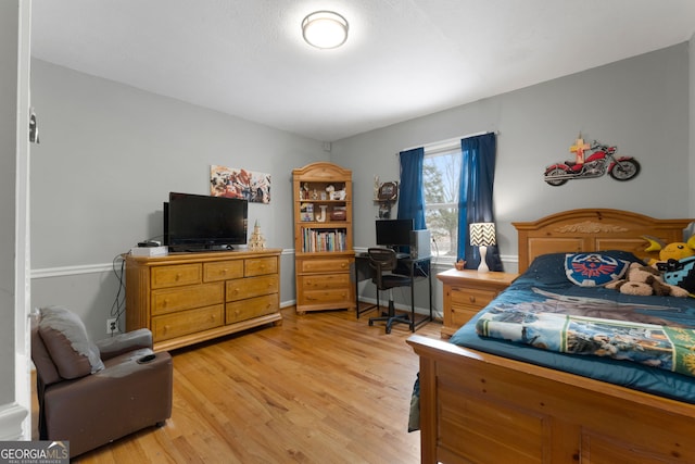 bedroom with light wood-style flooring and baseboards