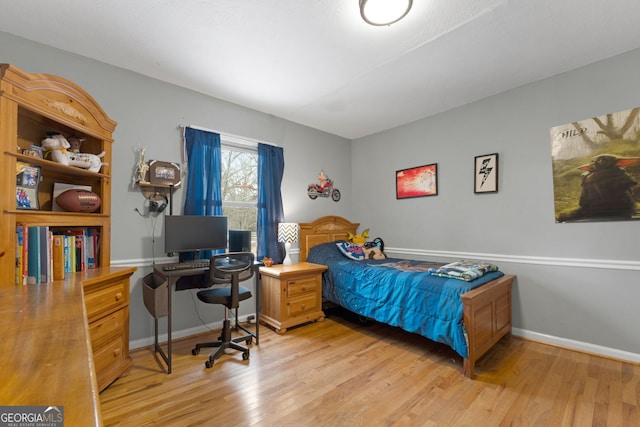 bedroom featuring light wood finished floors and baseboards