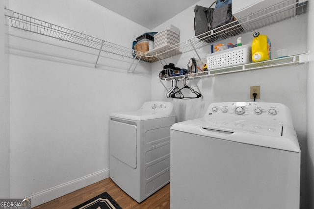 laundry area with laundry area, baseboards, wood finished floors, and independent washer and dryer