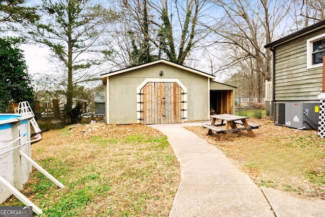 view of shed with central air condition unit and an outdoor pool