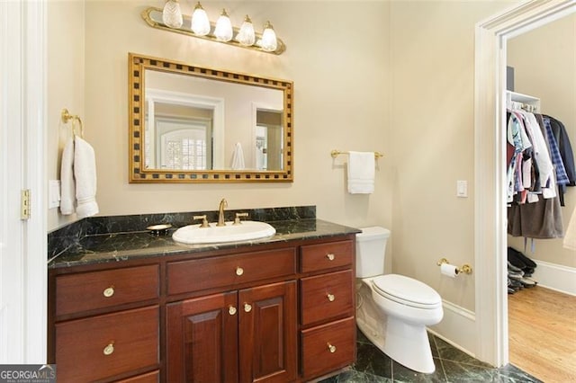 bathroom featuring toilet, vanity, and tile patterned flooring