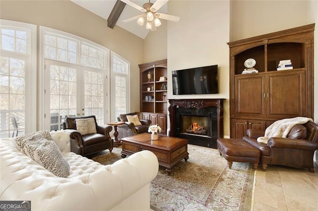 living room with french doors, beamed ceiling, a fireplace, high vaulted ceiling, and ceiling fan