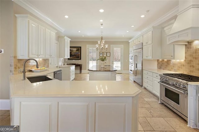 kitchen with premium range hood, a center island, pendant lighting, sink, and high quality appliances