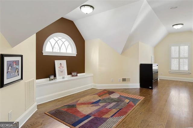 bonus room featuring lofted ceiling and dark hardwood / wood-style floors