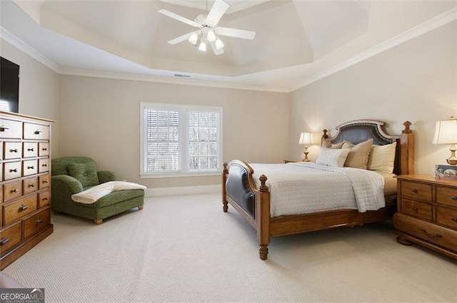 bedroom with ceiling fan, ornamental molding, light colored carpet, and a tray ceiling