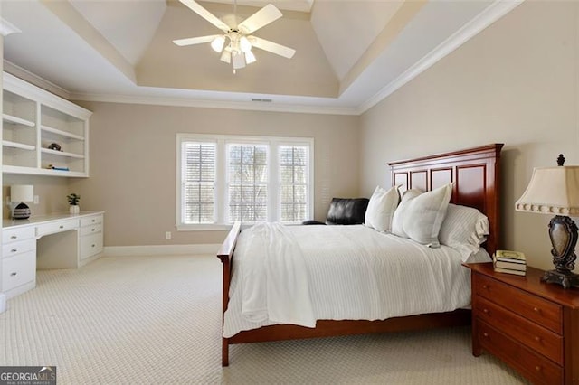 carpeted bedroom with ceiling fan, a tray ceiling, and crown molding