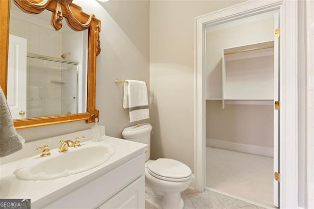 bathroom with toilet, vanity, tile patterned flooring, and a shower with door