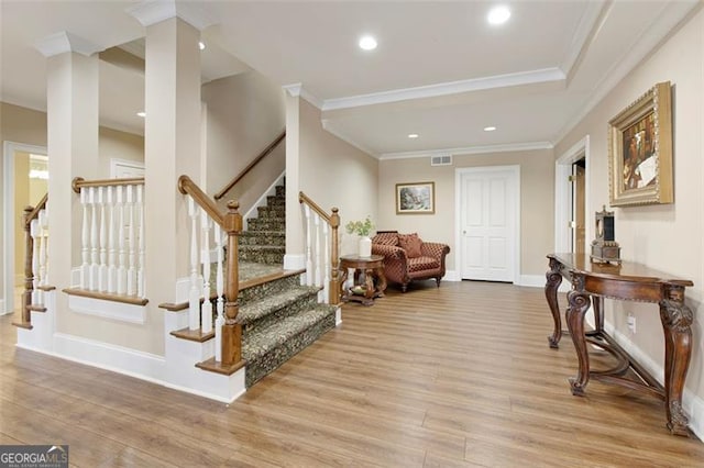 foyer with light wood-type flooring and crown molding