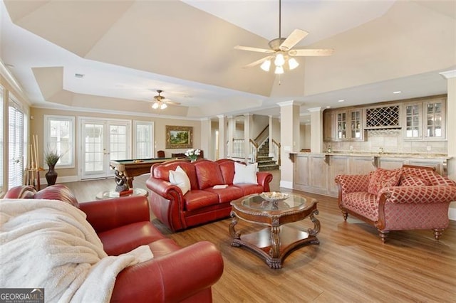 living room featuring french doors, billiards, a raised ceiling, bar area, and light hardwood / wood-style flooring