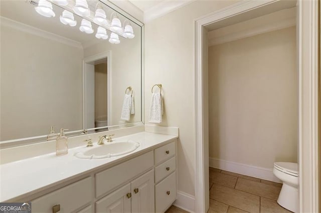 bathroom with toilet, vanity, tile patterned flooring, and ornamental molding