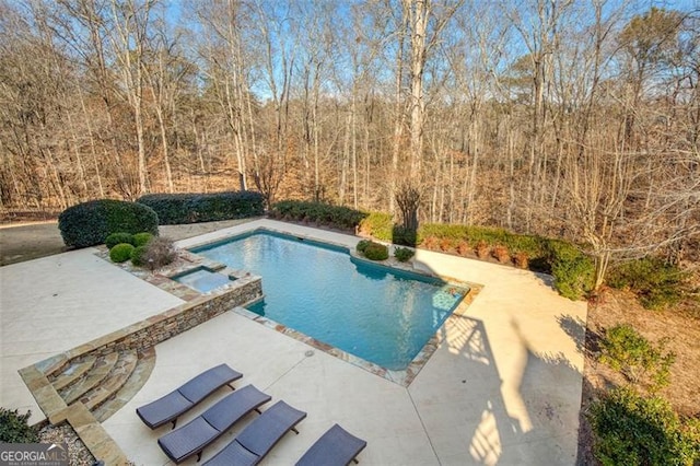 view of pool with a patio area and an in ground hot tub