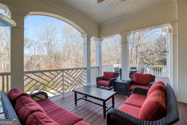 wooden deck with ceiling fan and outdoor lounge area