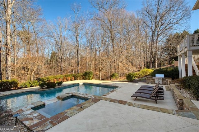 view of swimming pool featuring an in ground hot tub, a patio area, and area for grilling