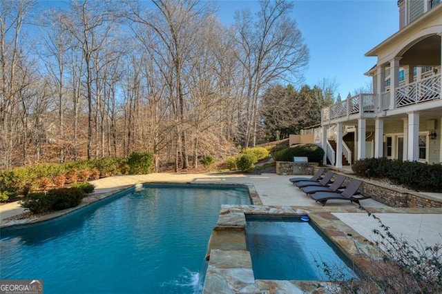 view of swimming pool featuring an in ground hot tub and a patio