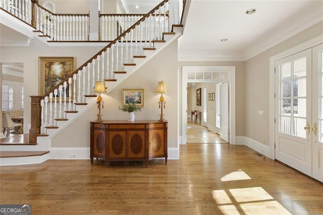 entryway with french doors, ornamental molding, and hardwood / wood-style floors