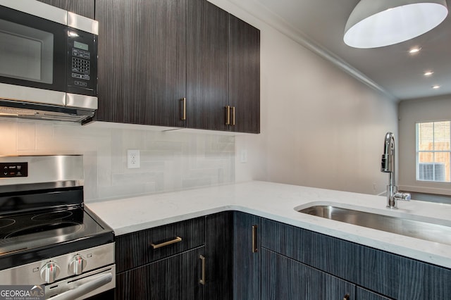 kitchen with decorative backsplash, sink, crown molding, and stainless steel appliances