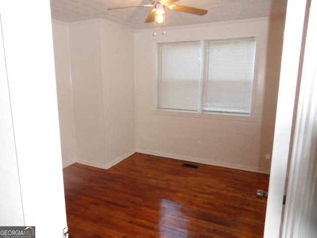 spare room with ceiling fan, ornamental molding, and dark hardwood / wood-style floors