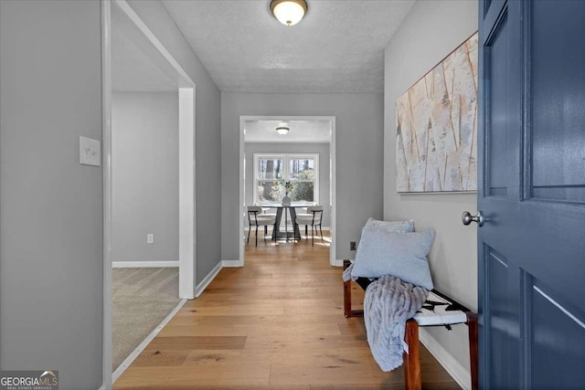 hallway featuring a textured ceiling and hardwood / wood-style floors