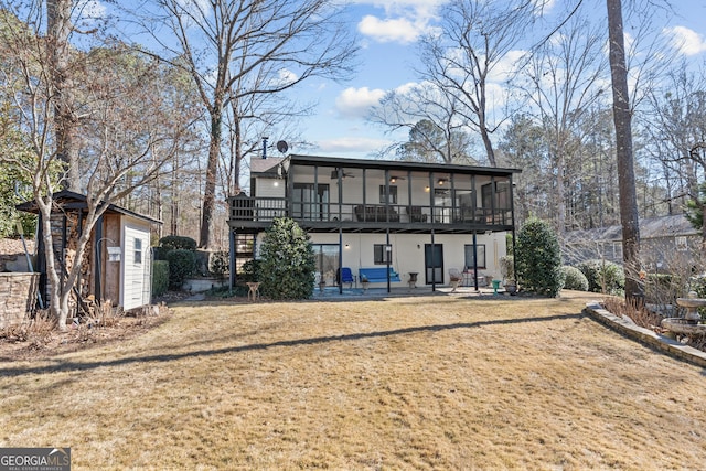 back of house featuring a patio area, a shed, a yard, and a sunroom