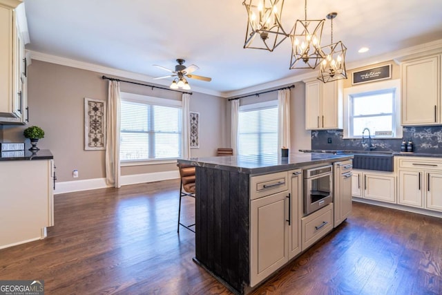 kitchen with backsplash, a center island, crown molding, and hanging light fixtures