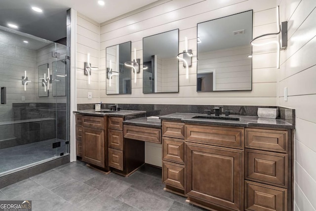 bathroom with a shower with shower door and vanity