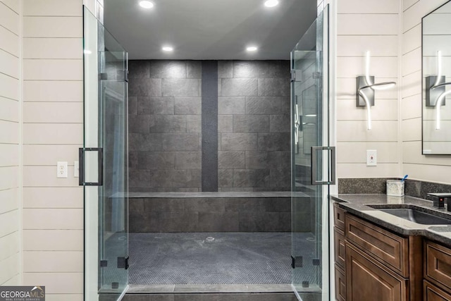 bathroom with walk in shower, vanity, and wooden walls