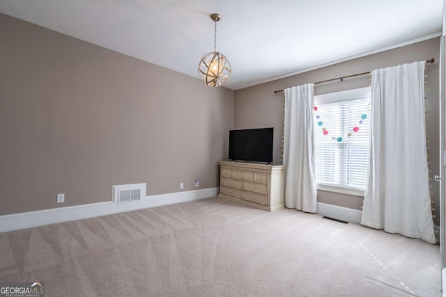 unfurnished living room with light carpet and an inviting chandelier