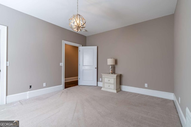 unfurnished bedroom with light colored carpet and a chandelier