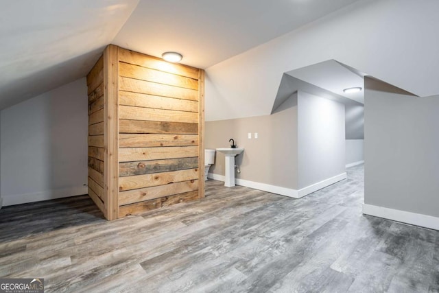 bonus room with wood-type flooring and vaulted ceiling