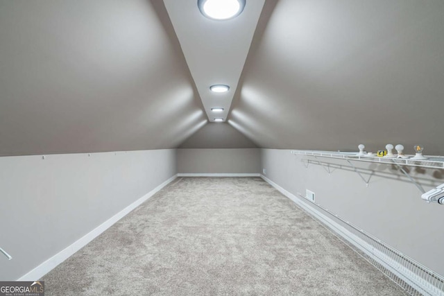 bonus room with light carpet and vaulted ceiling