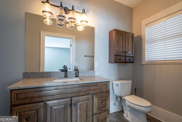 bathroom featuring toilet, hardwood / wood-style flooring, and vanity